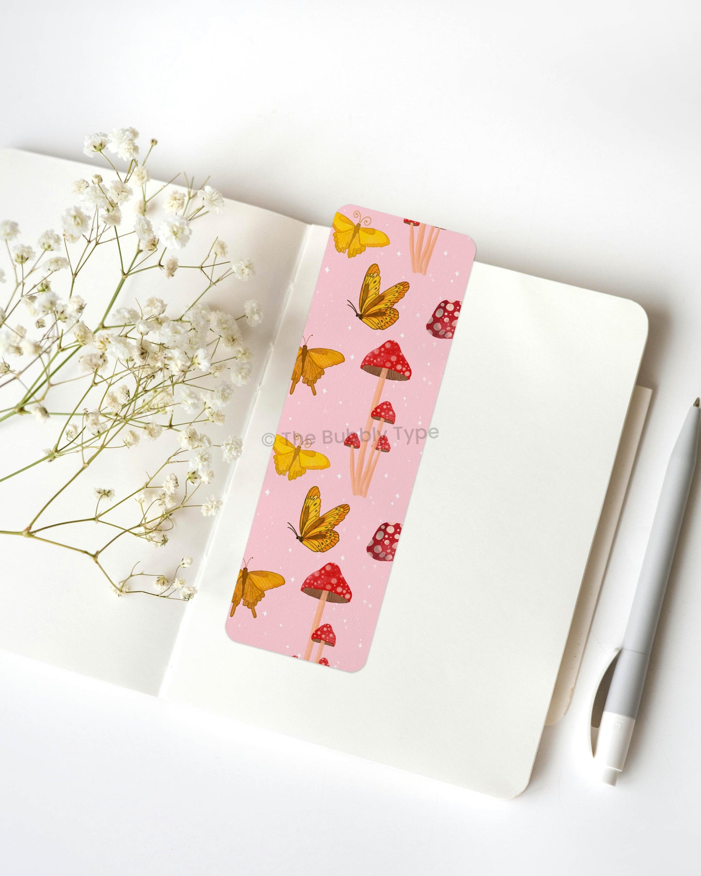 Magical Butterfly & Mushroom Print Bookmark – Step into a storybook world with this hand-illustrated bookmark, featuring bright yellow butterflies fluttering among red-capped toadstools on a soft pink background. With its whimsical and nature-inspired aesthetic, this bookmark is a must-have for fans of cottagecore, fairycore, and enchanted forest vibes. Made from 100% recycled paper, this double-sided beauty is durable, eco-friendly, and finished with rounded corners for an elegant touch. A dreamy companion