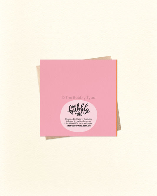 Back of the card with a pink background, featuring The Bubbly Type logo and printing details. Shown with a kraft brown envelope. Printed in Australia using sustainable materials.