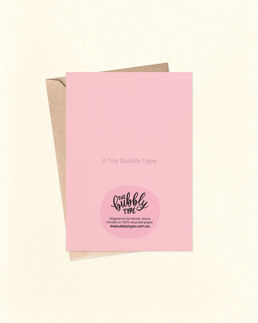 Back of the card with a pink background, featuring The Bubbly Type logo and card details. Displayed with a kraft brown envelope. Proudly designed and printed in Australia on sustainable materials.