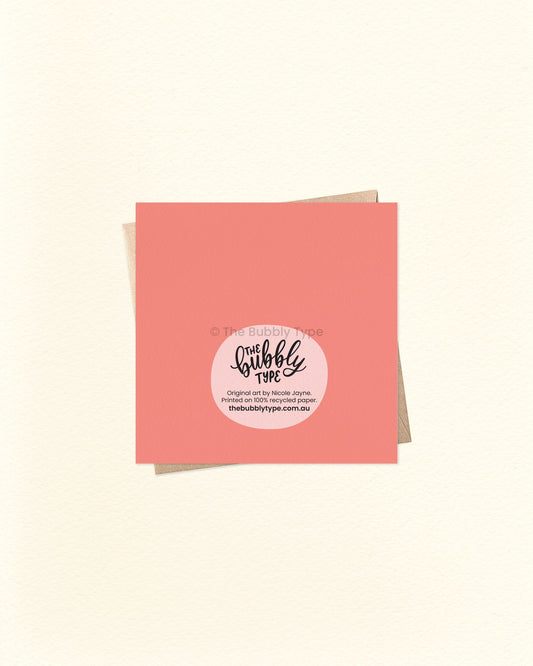 Back of the card with a vibrant peach-pink background, featuring The Bubbly Type logo and print details. Printed sustainably in Australia. Shown with a kraft brown envelope.