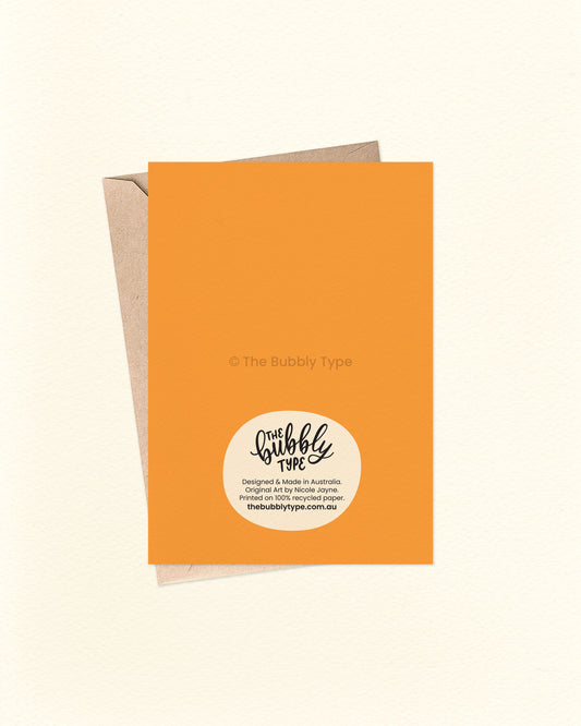Back of the card with a bright orange background, displaying The Bubbly Type logo and card details. Shown with a kraft brown envelope. Designed and printed sustainably in Australia.