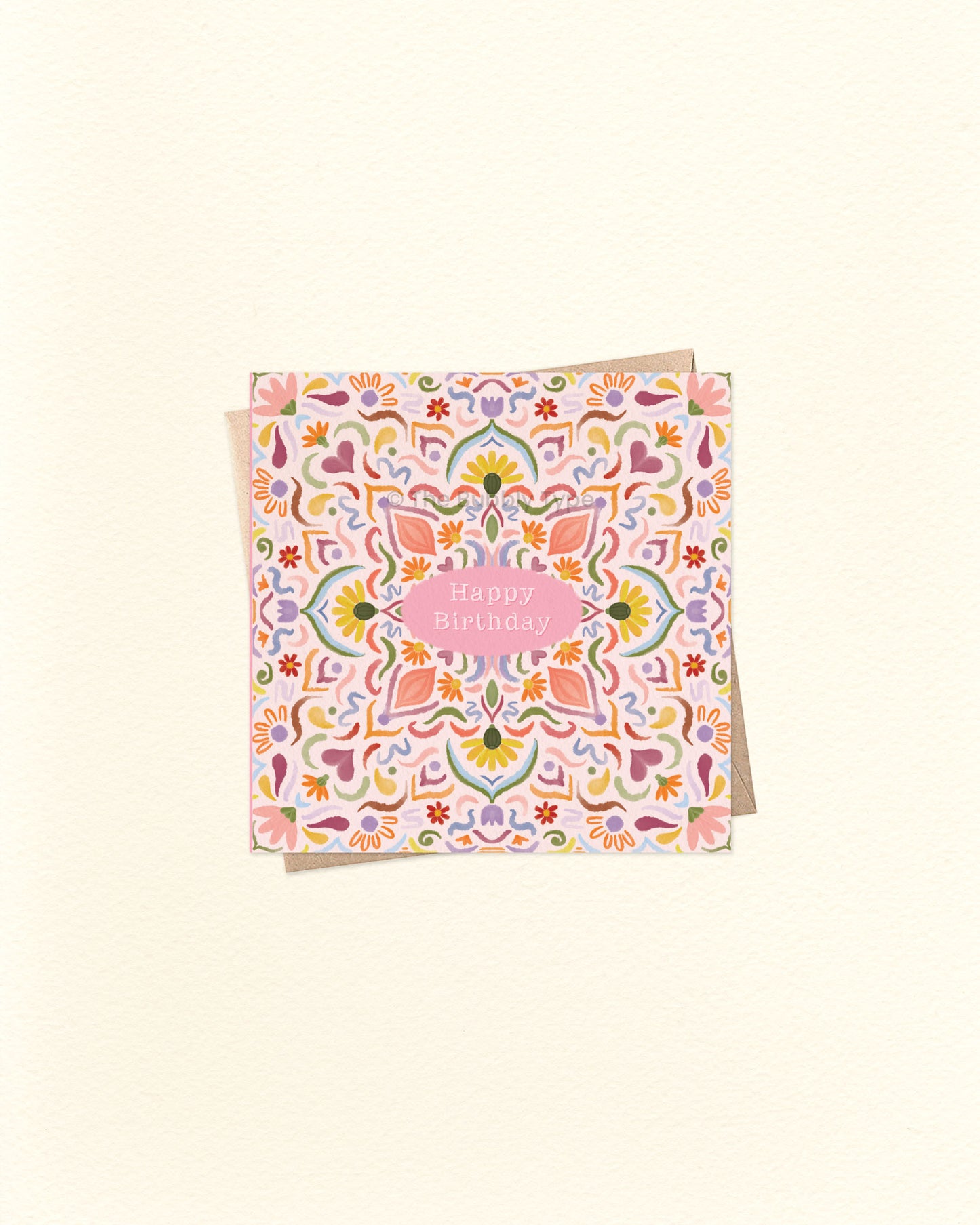 Front of 10cm square birthday card featuring a watercolour tile pattern in warm, vibrant colours – including pink, orange, blue, and purple. “Happy Birthday” is written in small text at the centre. Paired with a brown kraft envelope. A colourful and artistic Australian made birthday card by The Bubbly Type.