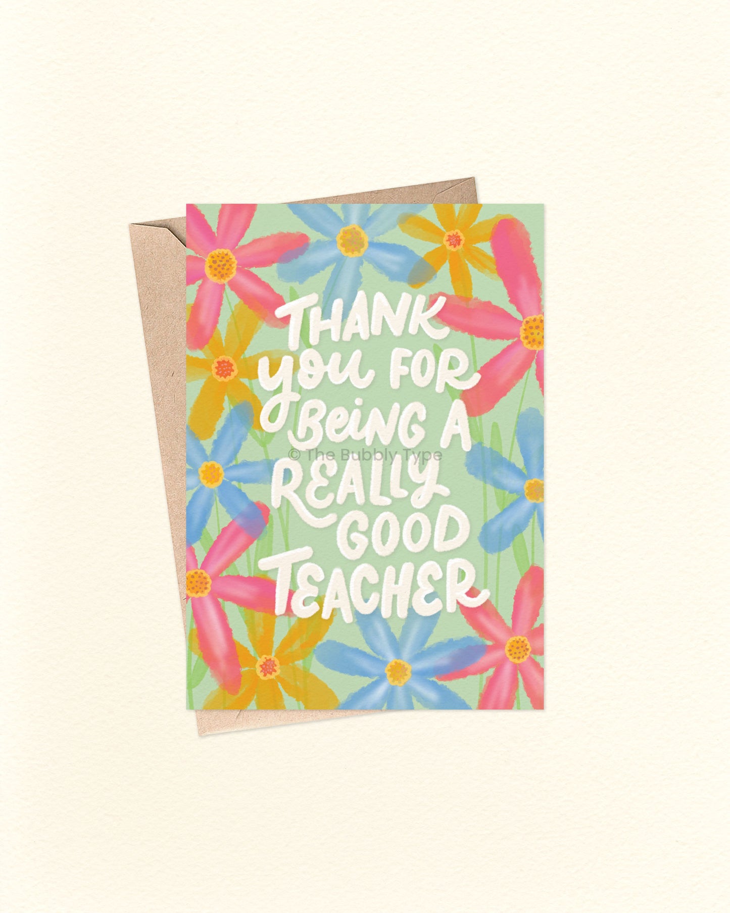 Front of A6 greeting card featuring a hand-lettered message that reads, “Thank you for being a really good teacher,” surrounded by a floral watercolour design with pink, blue, and yellow flowers. Set on a soft pale green background. A thoughtful Australian made card by The Bubbly Type – perfect for teacher appreciation, end of term gifts, or saying thanks to an educator. Shown with a brown kraft envelope.