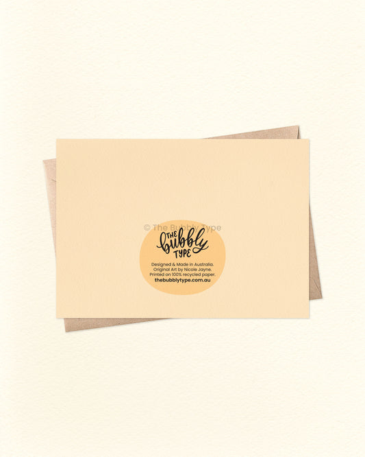 Back of the card with a matching pale yellow cream background, showing The Bubbly Type logo and card details. Displayed with a kraft brown envelope. Proudly printed in Australia using sustainable materials.