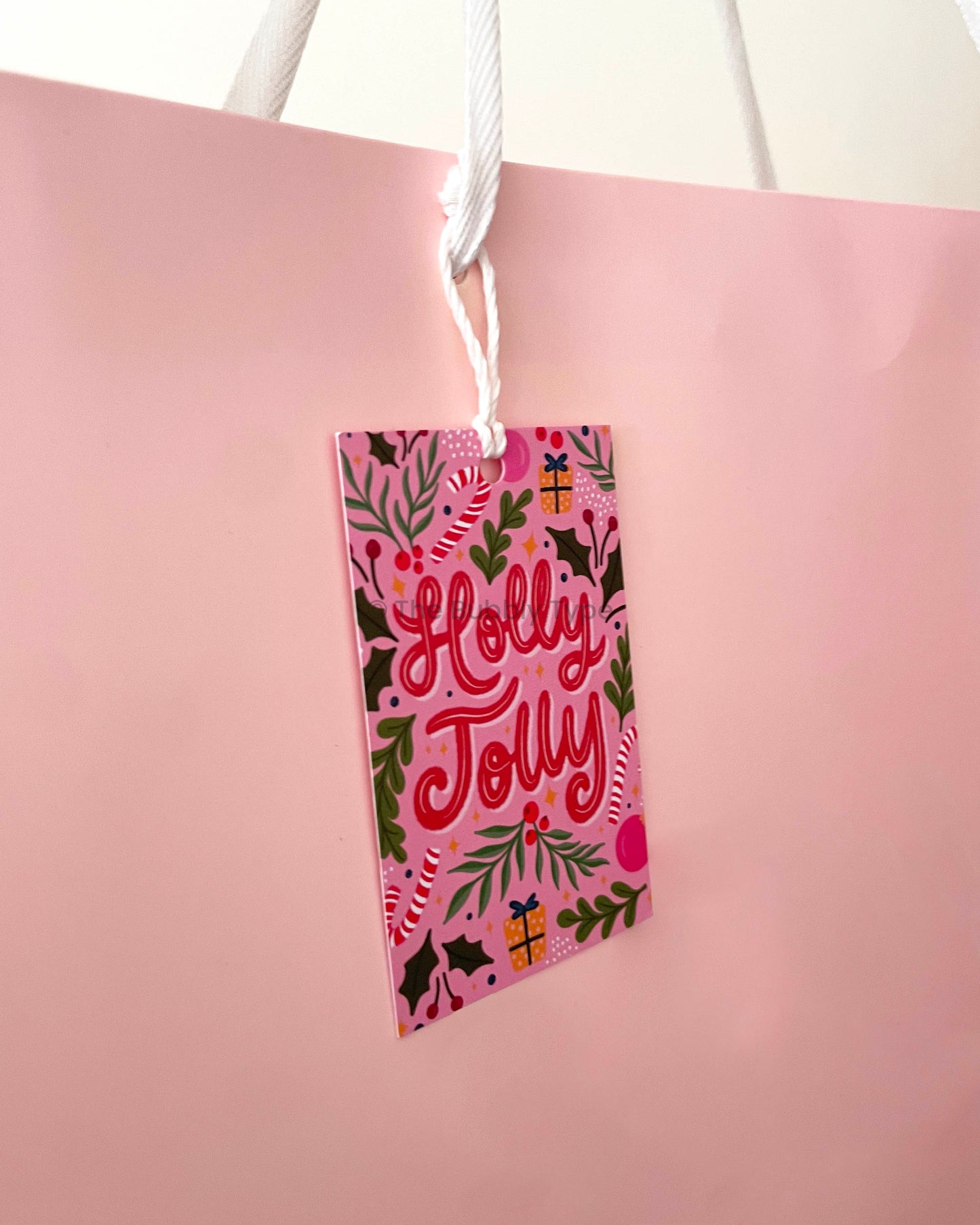 Bubbly Christmas tag tied to a present-ready light pink gift bag. Showcases how the tag adds festive flair. Buy bold and modern gift tags for Christmas in Australia.