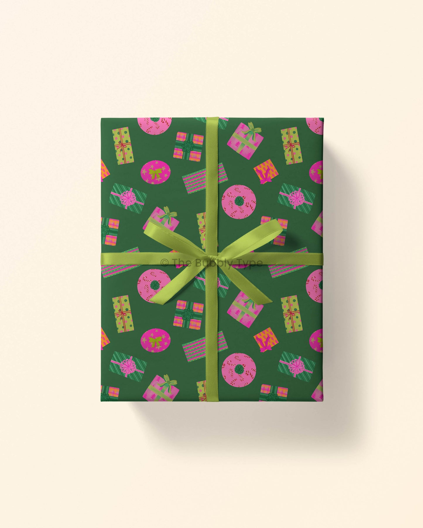 Top view of a gift wrapped in present-themed Christmas wrapping paper with stacks of colourful pink and orange gift illustrations on a deep emerald green background. A great way to wrap festive gifts for friends and family.