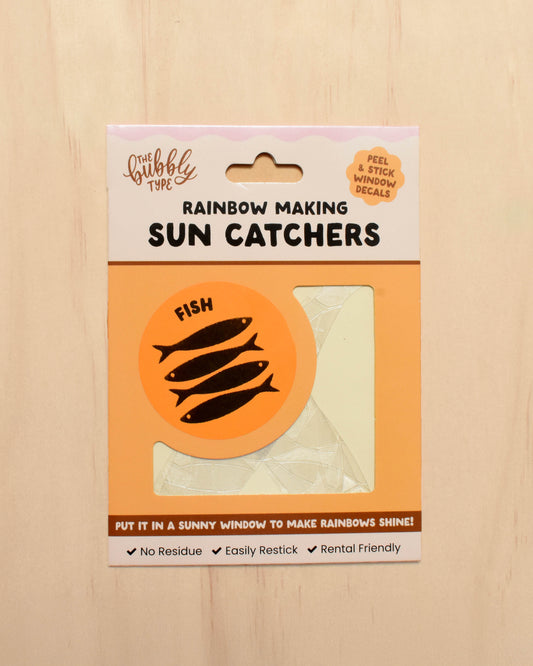 Packaging of rainbow making sun catchers with fish design on a wooden surface