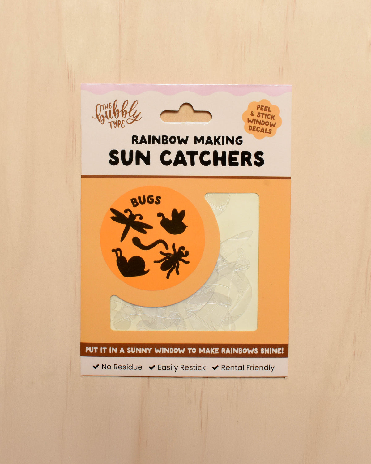 Packaging of rainbow-making sun catchers with a wooden background