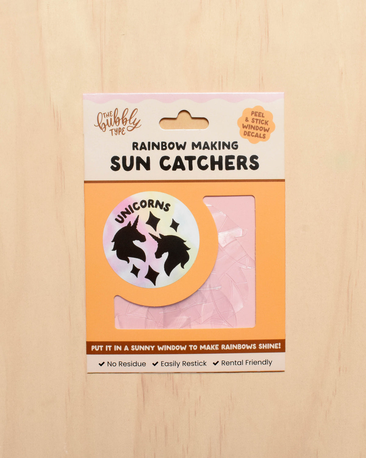 Packaging of sun catchers with a unicorn design on a wooden surface