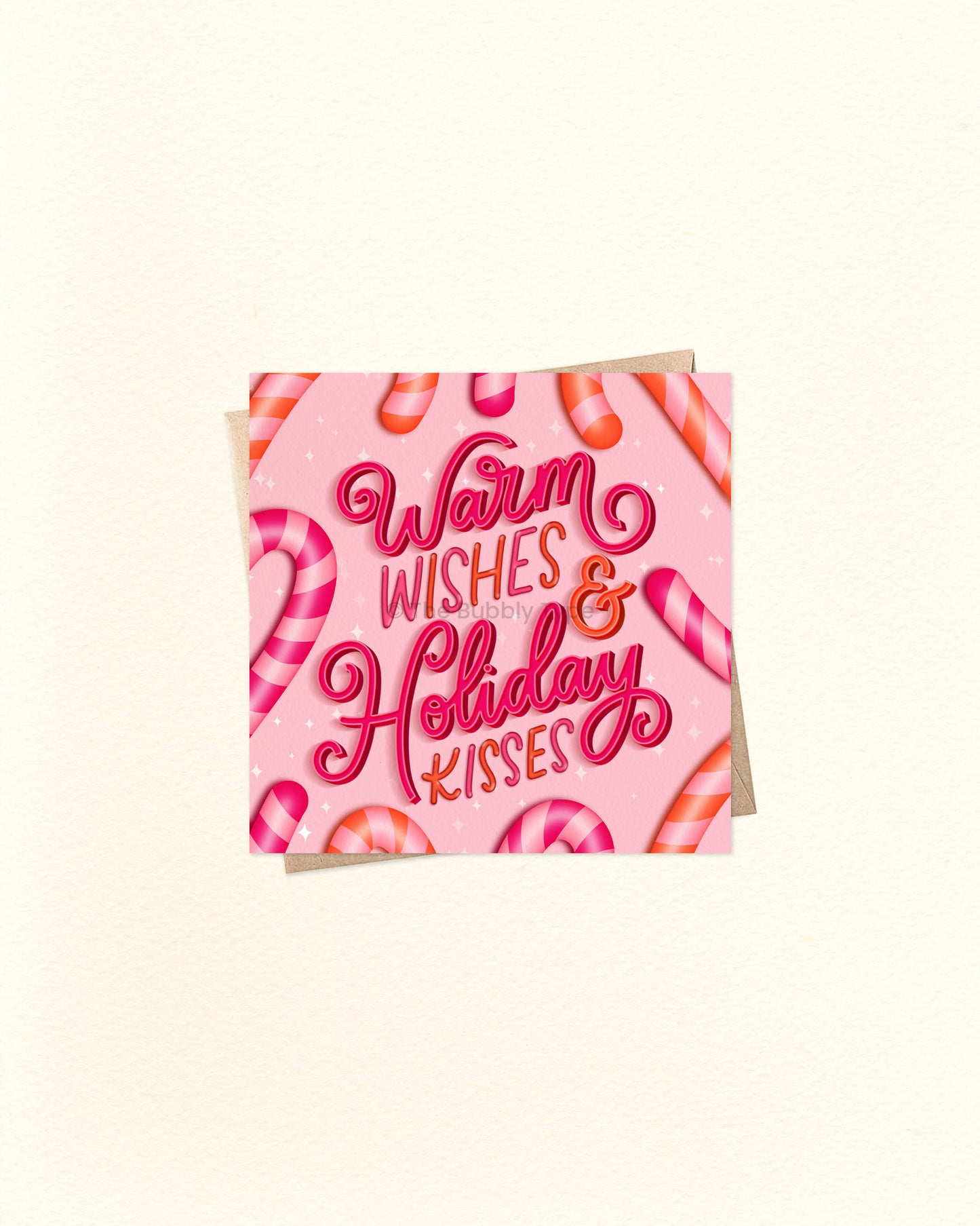Square Christmas greeting card with cheerful festive design and message ‘Warm Wishes and Holiday Kisses’, shown on a brown kraft envelope. Cute and colourful Christmas card, buy in Australia for friends or loved ones.