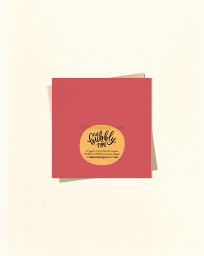 Back of the card with a maroon and yellow background, showing The Bubbly Type logo and print details. Shown with a kraft brown envelope. Designed and printed in Australia using eco-conscious materials.