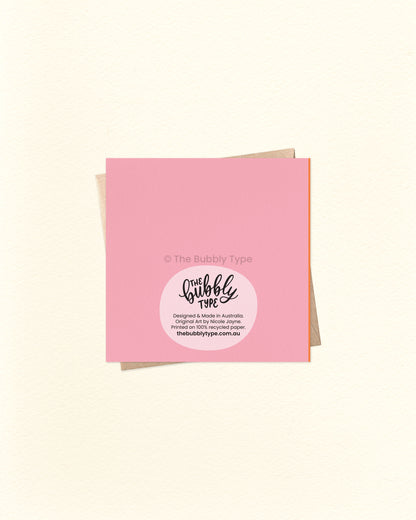 Back of the card with a pink background, featuring The Bubbly Type logo and printing details. Shown with a kraft brown envelope. Printed in Australia using sustainable materials.
