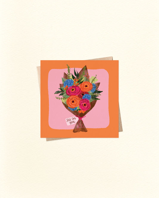 Front of 10cm square everyday greeting card featuring a bouquet of orange, pink, and blue flowers with green foliage, wrapped in brown paper with a tag that reads “Just For You.” Set on a pink background with an orange border. Paired with a brown kraft envelope. A versatile Australian made card by The Bubbly Type – perfect for thank yous, thinking of you, or gift-giving occasions.