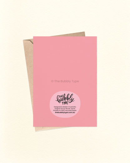 Back of the card with a matching pink background, showing The Bubbly Type logo and card details. Displayed with a kraft brown envelope. Proudly designed and printed in Australia.