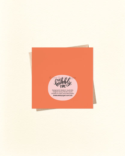 Back of the card with a bright orange background, displaying The Bubbly Type logo and print details. Shown with a brown kraft envelope. Designed and printed sustainably in Australia.