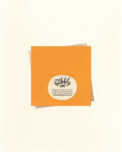 Back of the card with a bright orange background, featuring The Bubbly Type logo and print details. Shown with a kraft brown envelope. Proudly designed and printed in Australia on sustainable cardstock.