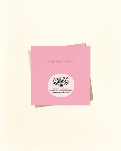 Back of the card with a pink background, featuring The Bubbly Type logo and print details. Displayed with a kraft brown envelope. Printed sustainably in Australia.
