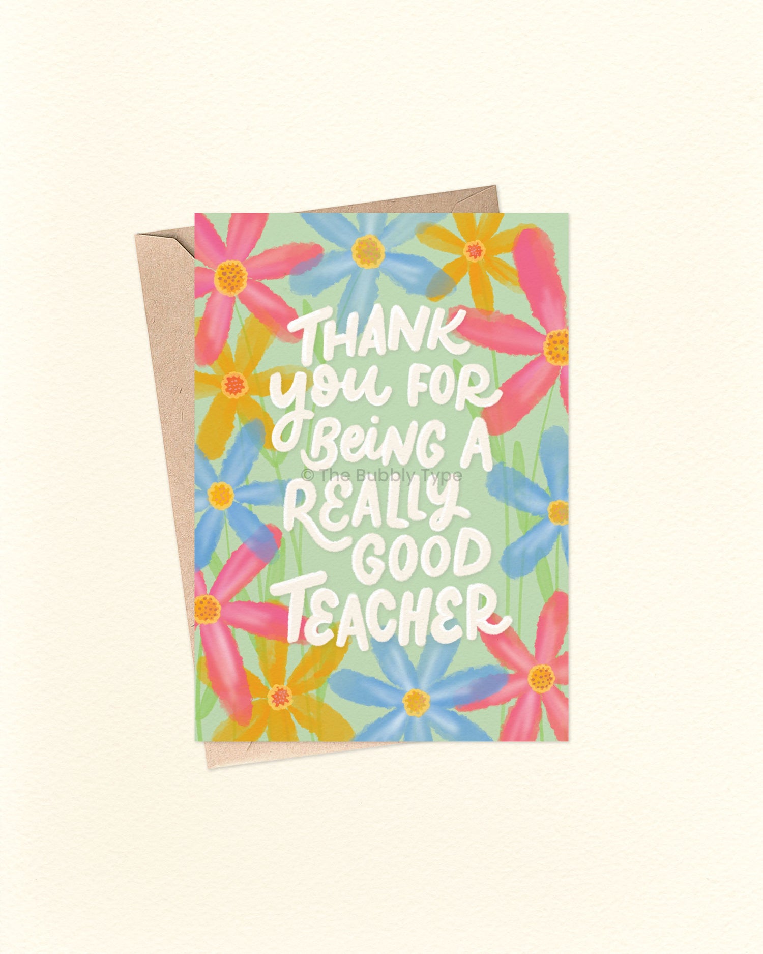 Front of A6 greeting card featuring a hand-lettered message that reads, “Thank you for being a really good teacher,” surrounded by a floral watercolour design with pink, blue, and yellow flowers. Set on a soft pale green background. A thoughtful Australian made card by The Bubbly Type – perfect for teacher appreciation, end of term gifts, or saying thanks to an educator. Shown with a brown kraft envelope.