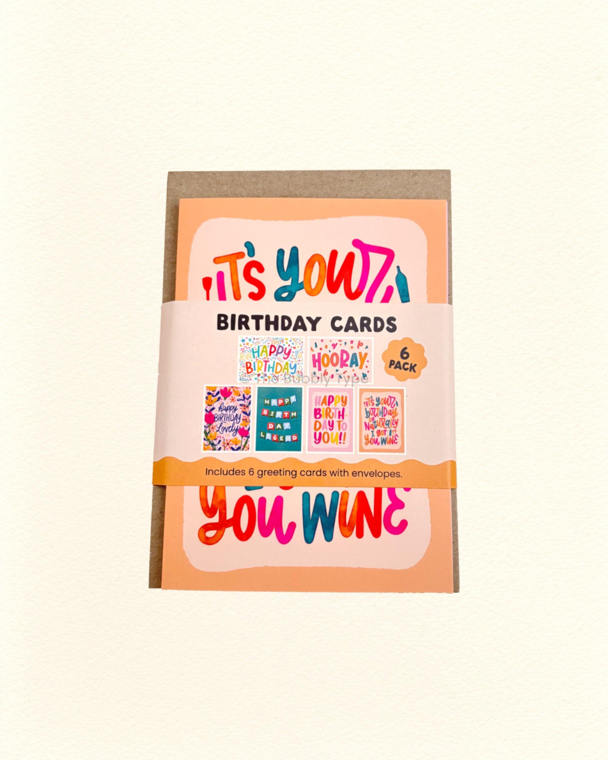 Pack of birthday cards with colourful text and illustrations on a beige background