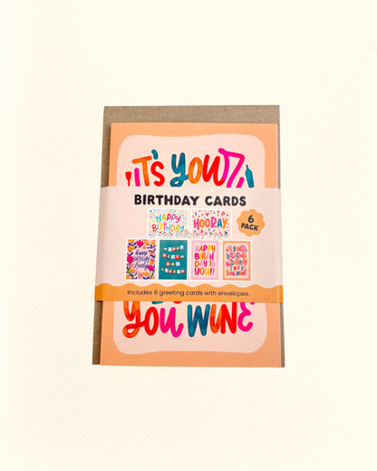 Pack of birthday cards with colourful text and illustrations on a beige background