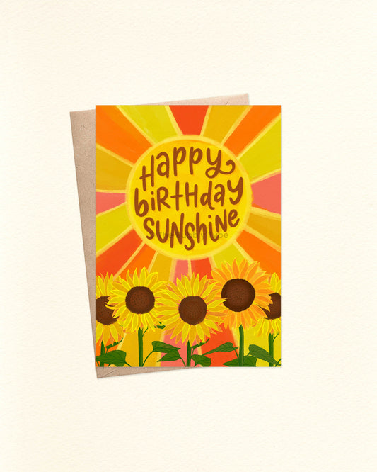 A6 birthday card with bold floral artwork and ‘Happy Birthday Sunshine’ message, displayed on a brown kraft envelope. Buy colourful birthday cards in Australia for friends who love bright, happy designs.