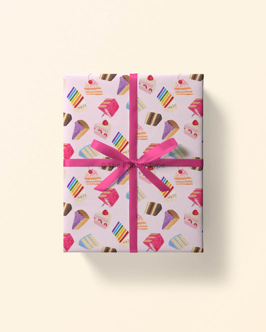 Image 1 (wrapped gift): Top view of a gift wrapped in birthday cake wrapping paper featuring colourful illustrated cakes on a pale pink background.