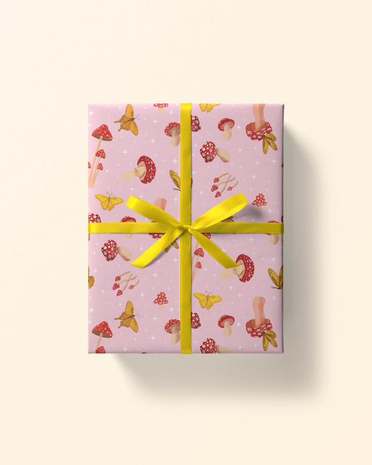 Top view of a gift wrapped in pink daisy gingham wrapping paper, showing white daisies on a pink checkered pattern.
