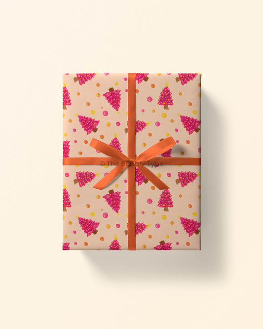Top view of a gift wrapped in Christmas tree wrapping paper with a mix of hand-drawn tree illustrations in festive colours.