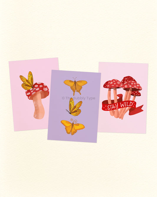 Three colourful A6 Postcards with butterfly and mushroom designs on a light pink background. Featuring original illustrations of red mushrooms and yellow butterflies. Printed on recycled paper in Australia.