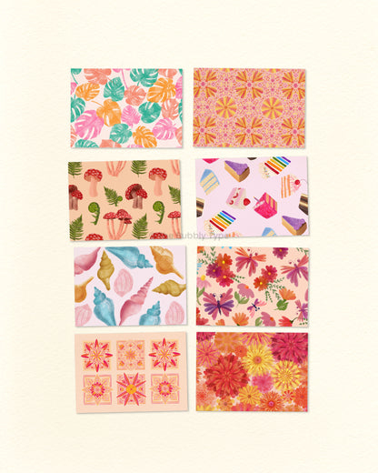 A set of 8 colourful patterned postcards arranged in a grid on a white background. Each postcard features a different pattern illustration; monstera leaves, spring florals, mushrooms and ferns, birthday cake, sea shells, butterflies and flowers, Flower tiles, foral burst.