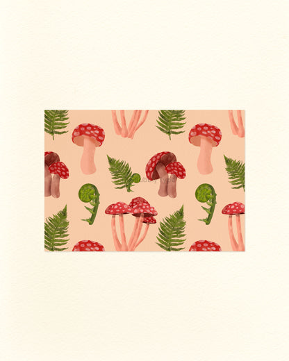 A postcard with an illustrated pattern of red mushrooms and green leafy ferns on a pale orange background