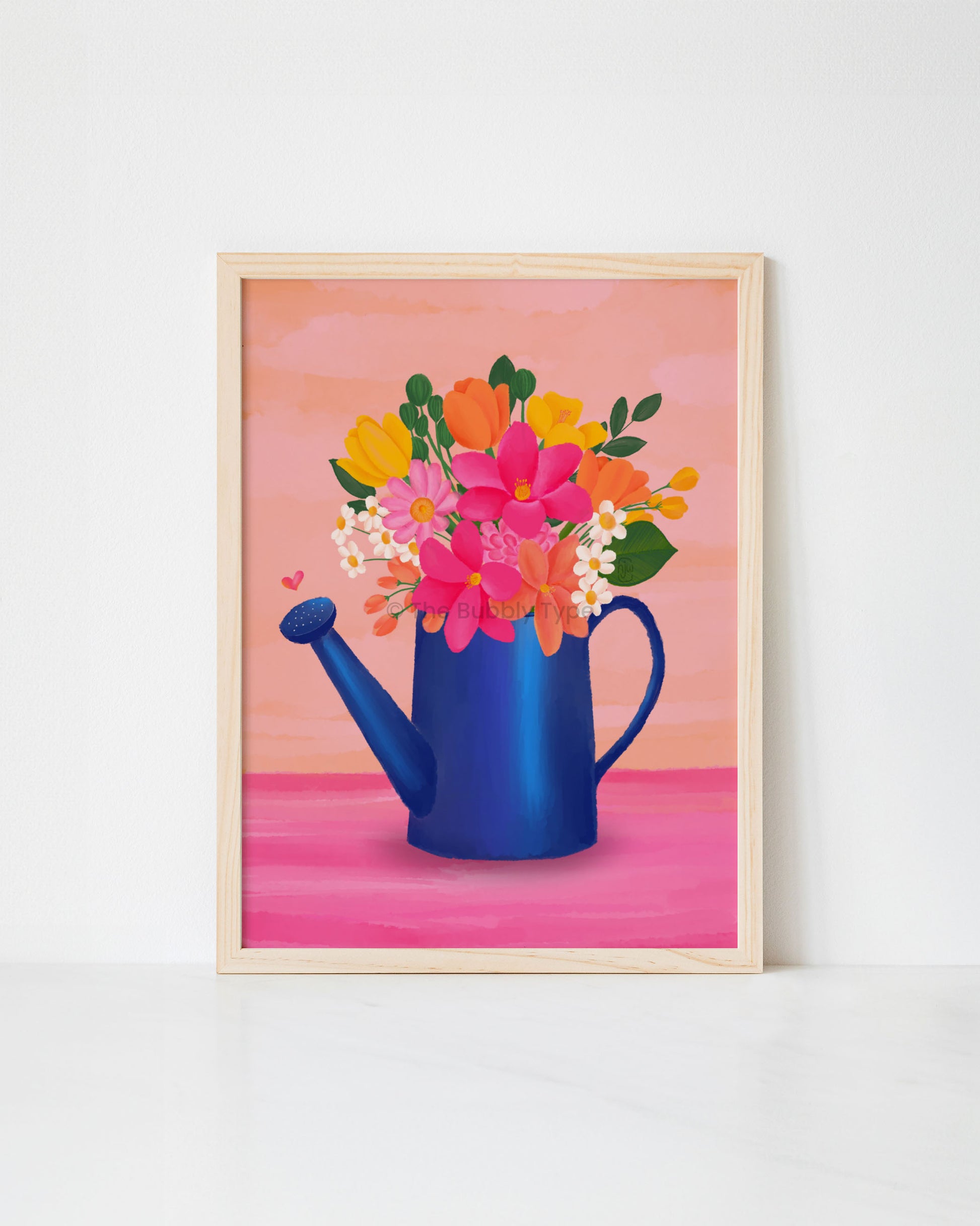 Framed artwork print of a blue watering can with colourful flowers on a pink background