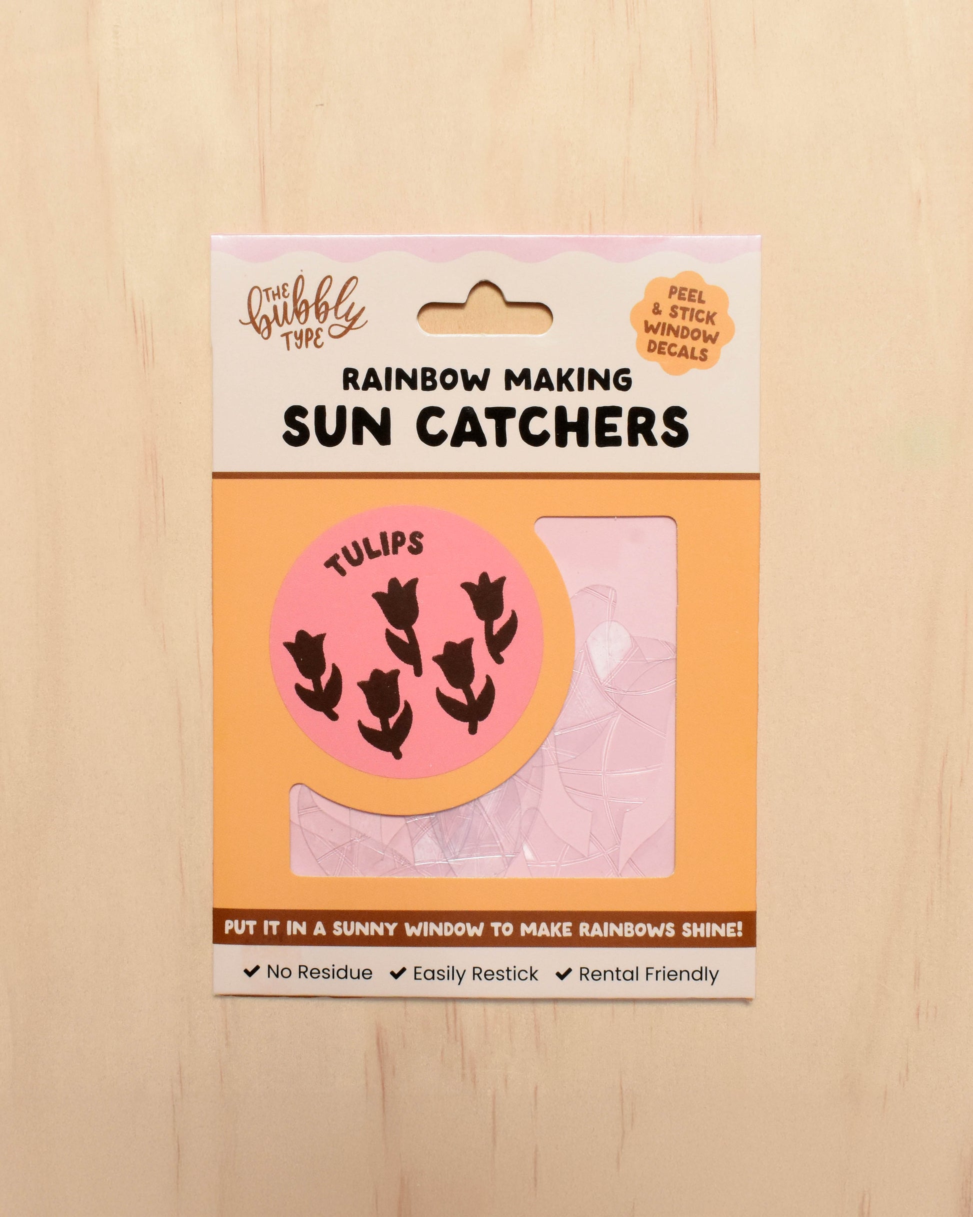 Packaging of rainbow-making sun catchers with tulip design on a wooden surface