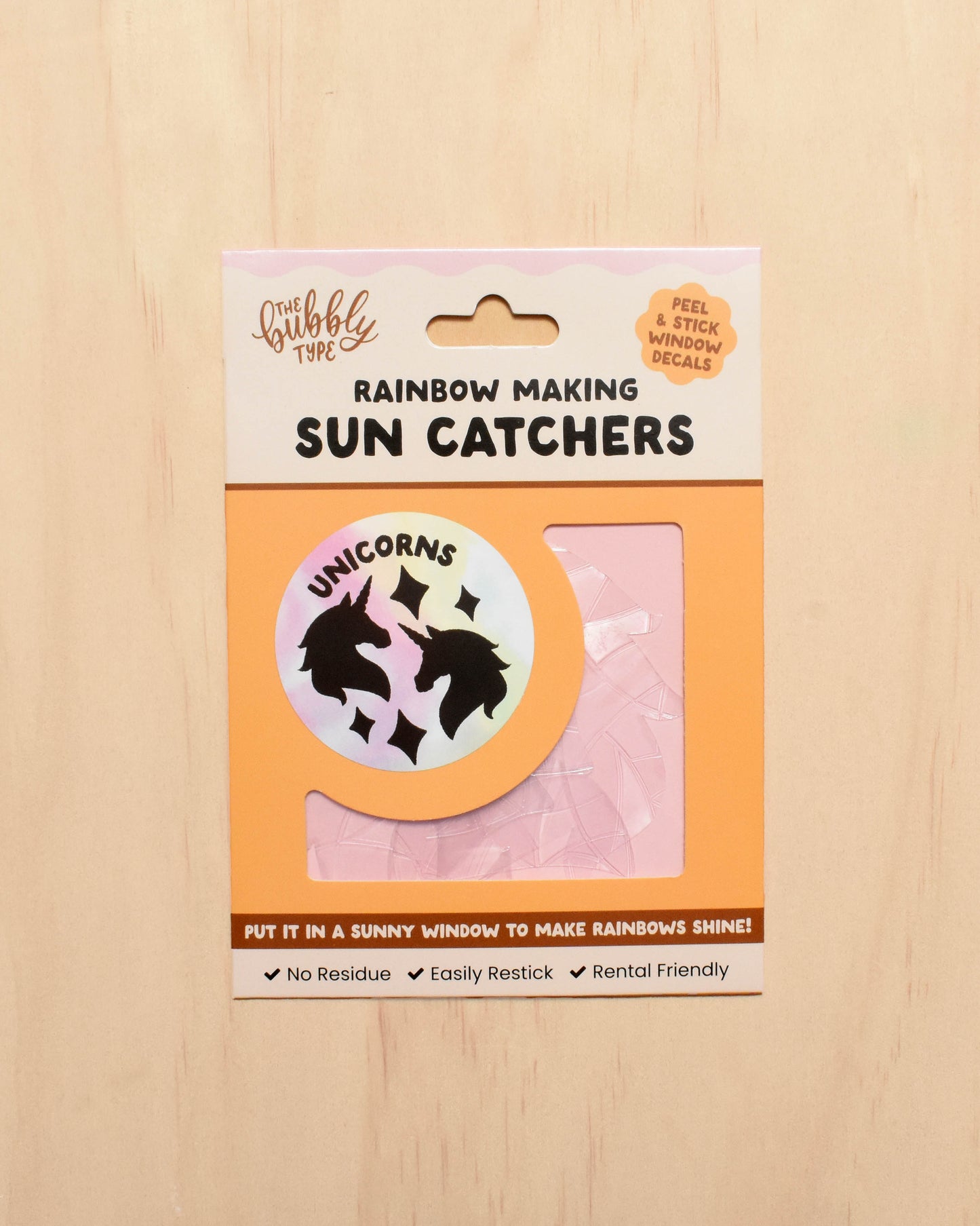 Packaging of sun catchers with a unicorn design on a wooden surface
