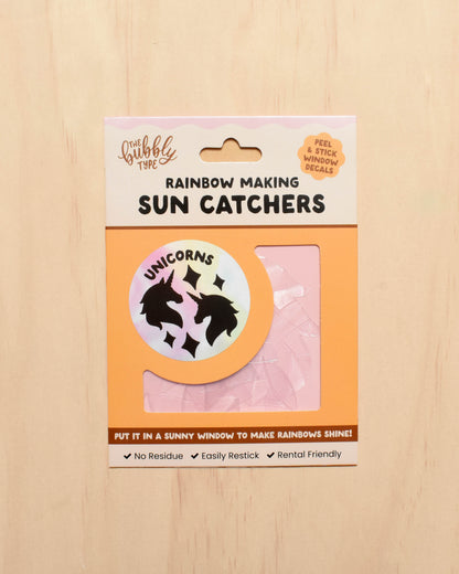 Packaging of sun catchers with a unicorn design on a wooden surface