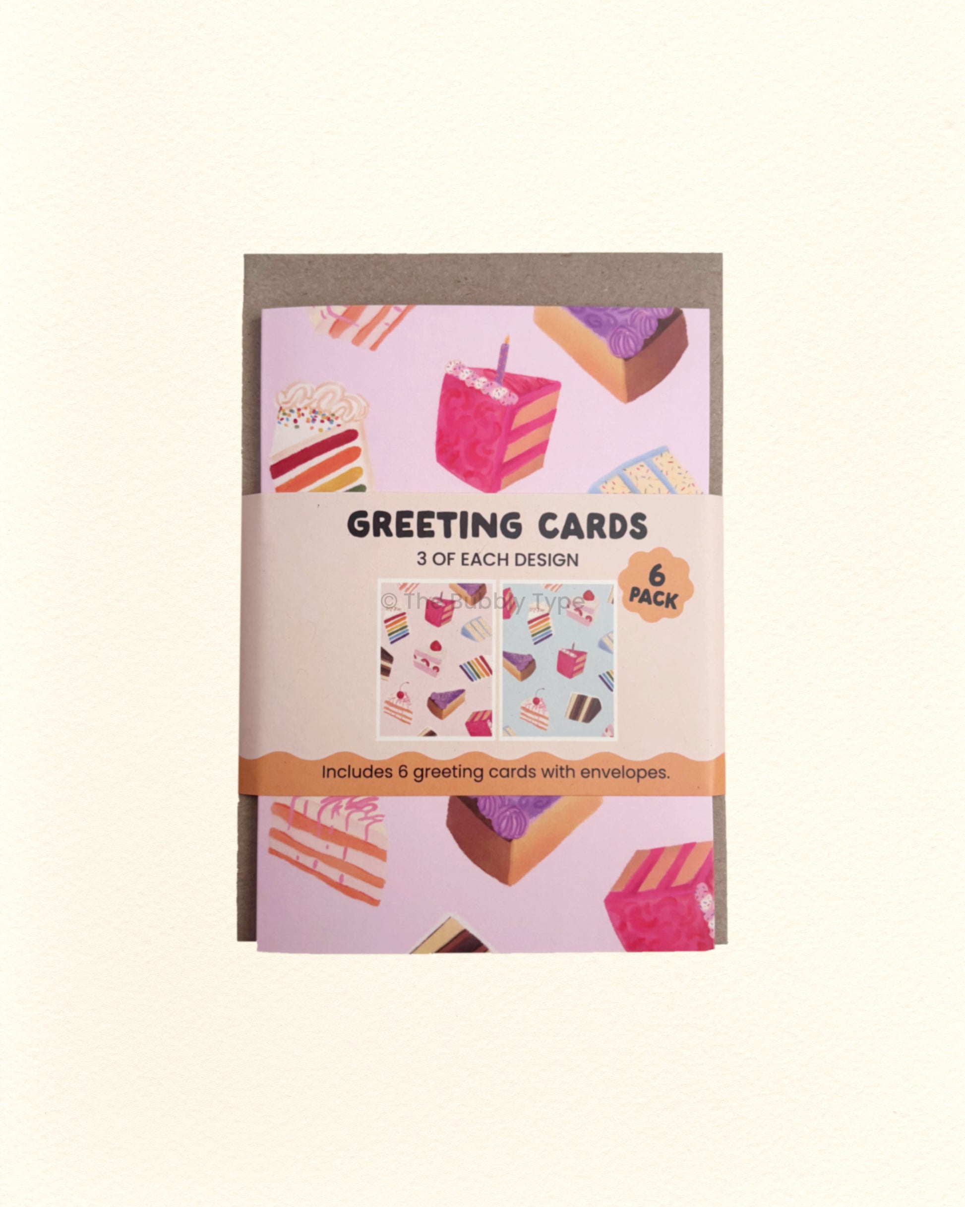 Pack of greeting cards with a pink and blue cake designs on a beige background