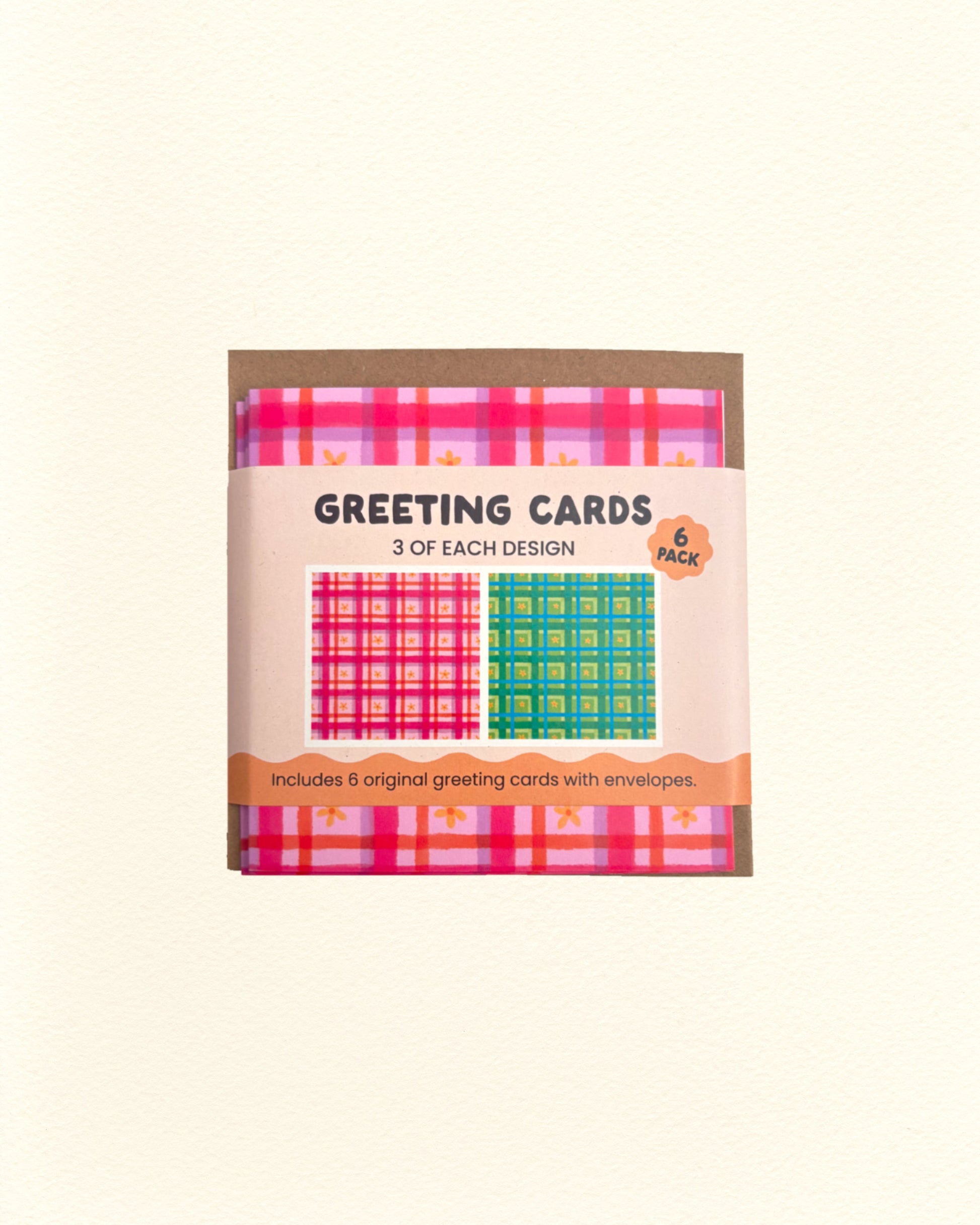 Pack of greeting cards with pink and green floral gingham designs on a beige background
