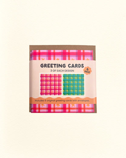 Pack of greeting cards with pink and green floral gingham designs on a beige background