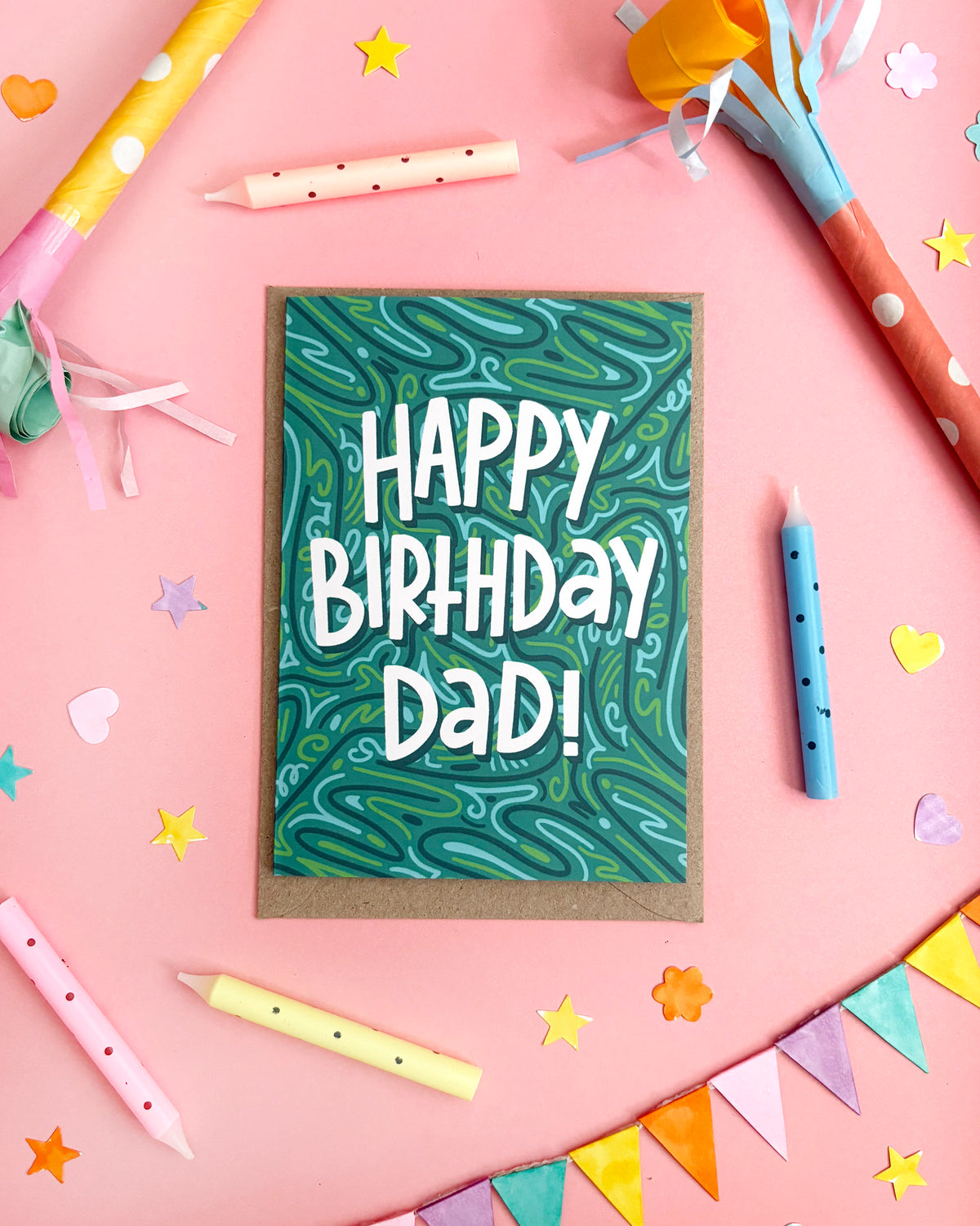 A birthday card with a green marbled pattern and the words 'HAPPY BIRTHDAY DAD!' in white, styled on a pink background with party candles, confetti, and bunting.