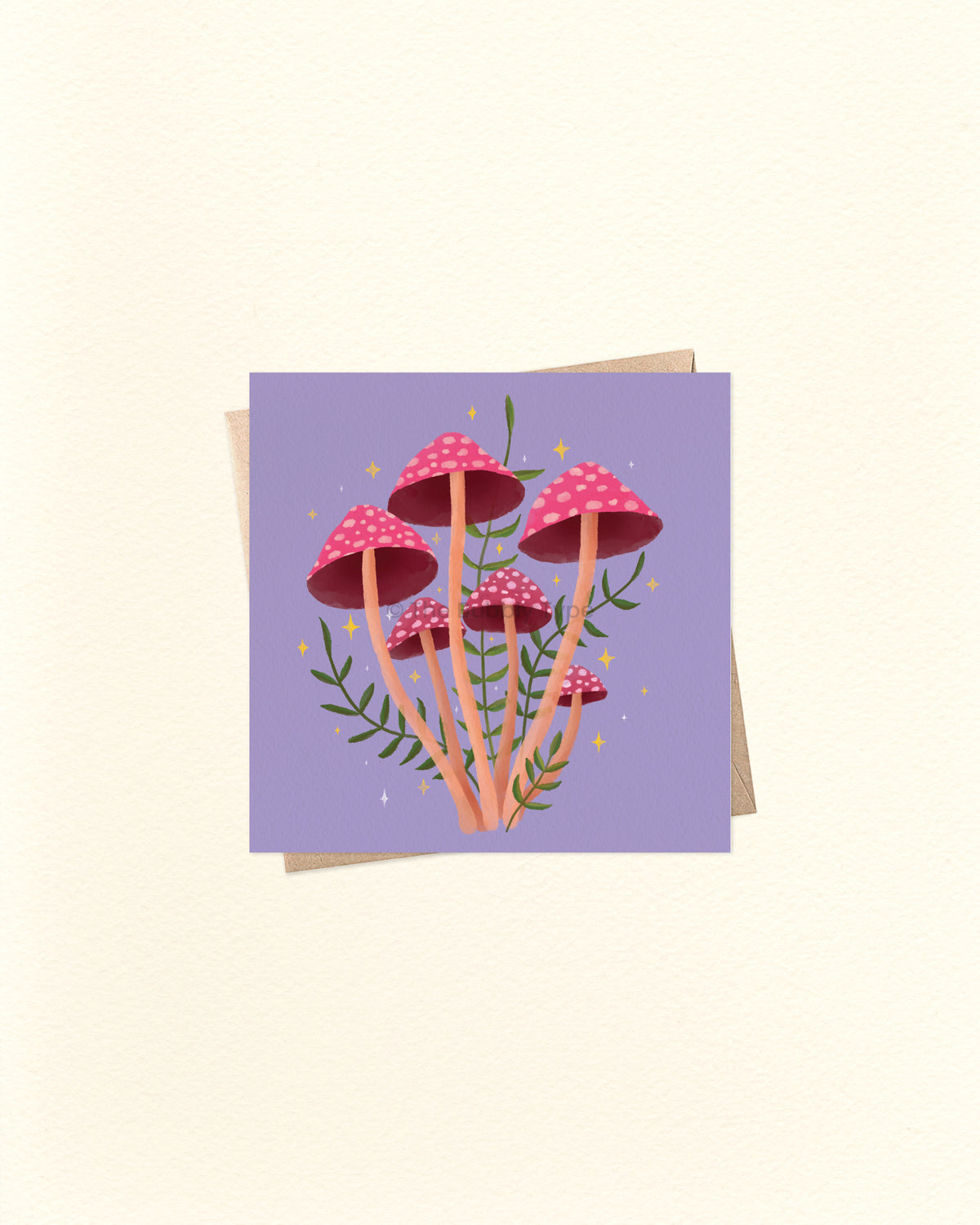 A square art print or card featuring a cluster of pink and red mushrooms with green stems on a lavender background, shown with a kraft envelope behind it on a warm off-white surface.