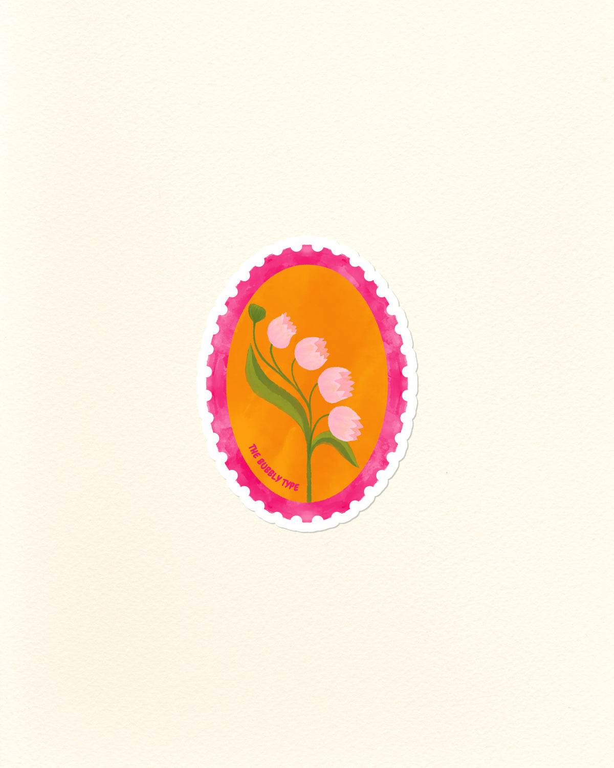 A die-cut sticker featuring a stylised lily of the valley flower illustration, set against a bright orange oval background with a pink scalloped postage stamp border, shown on a textured off-white paper background.