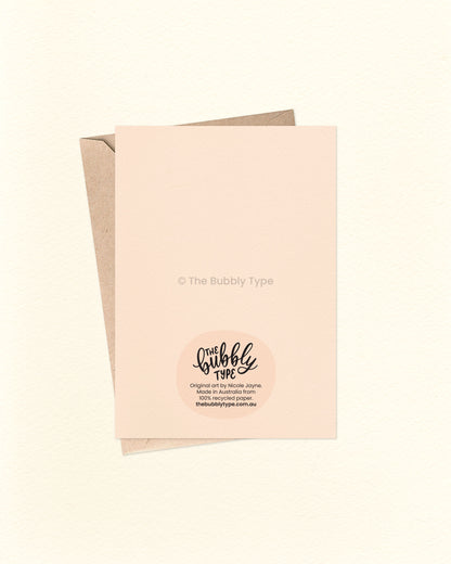 Back of the card with a matching pale creamy orange background, featuring The Bubbly Type logo and card details. Displayed with a kraft brown envelope. Sustainably printed in Australia.