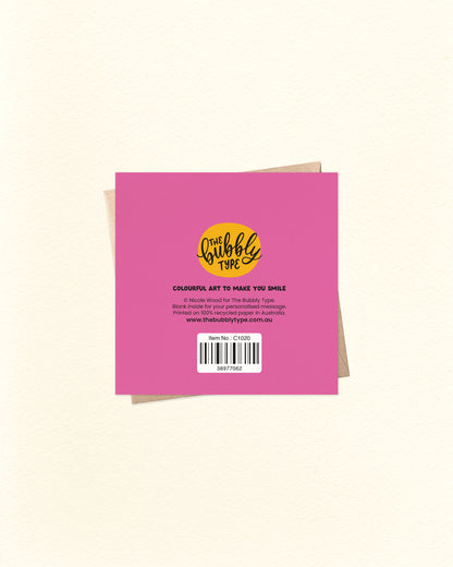 Back of a pink greeting card with a yellow logo and text with brown kraft envelope