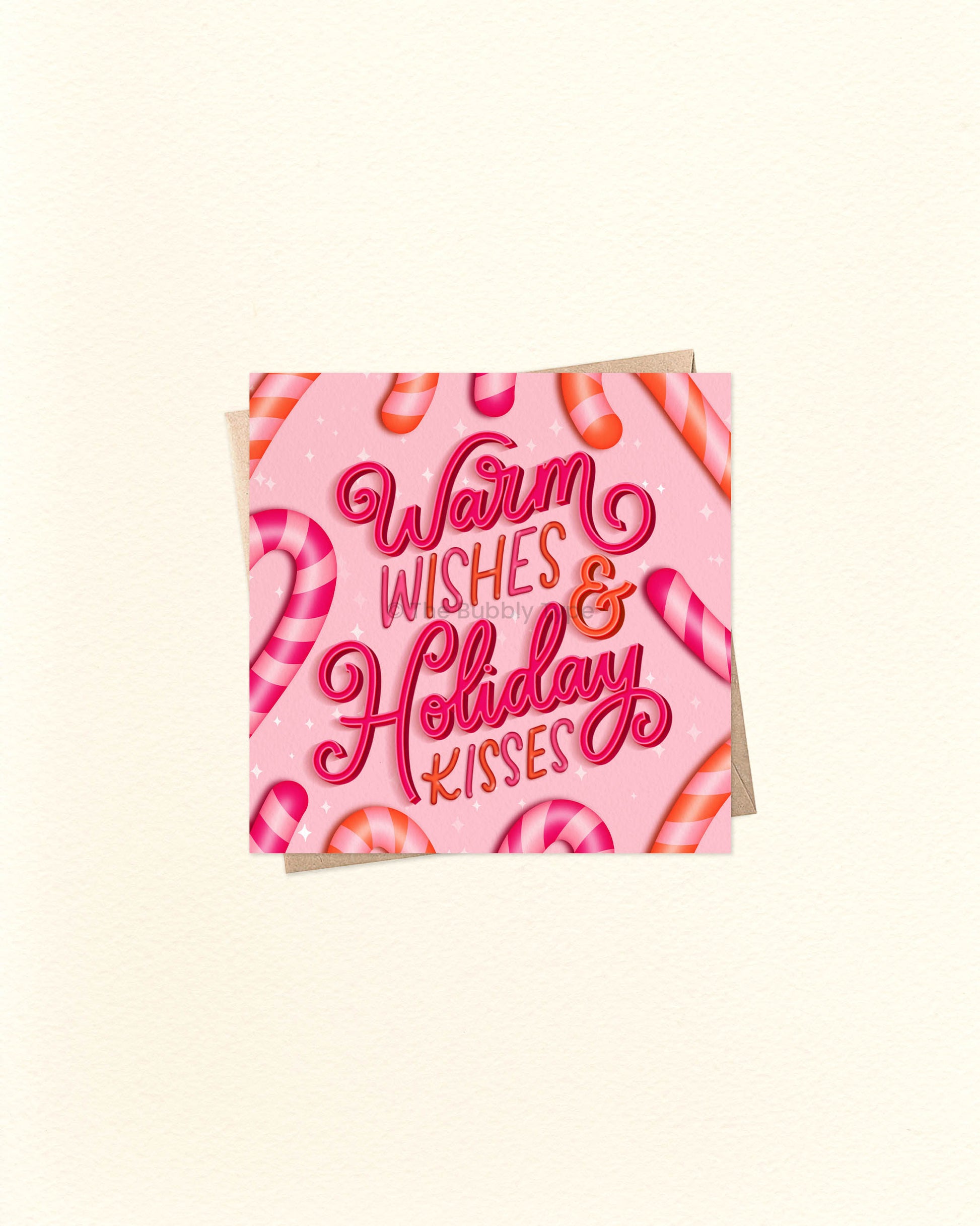 Square Christmas greeting card with cheerful festive design and message ‘Warm Wishes and Holiday Kisses’, shown on a brown kraft envelope. Cute and colourful Christmas card, buy in Australia for friends or loved ones.