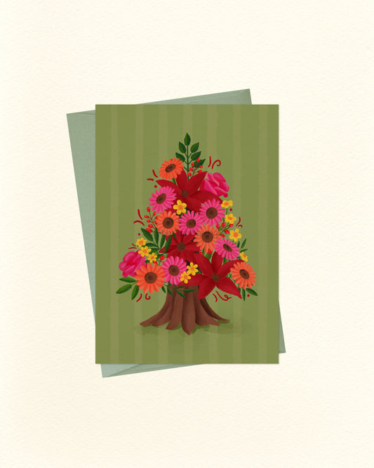 A greeting card featuring a colorful bouquet of flowers arranged in the shape of a tree, set against a striped olive green background, with a matching green envelope behind it on a cream-colored surface.