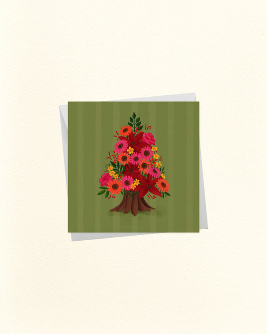 A square greeting card with a green striped background and a colourful floral tree illustration in the centre, shown with a white envelope behind it on a light cream background.