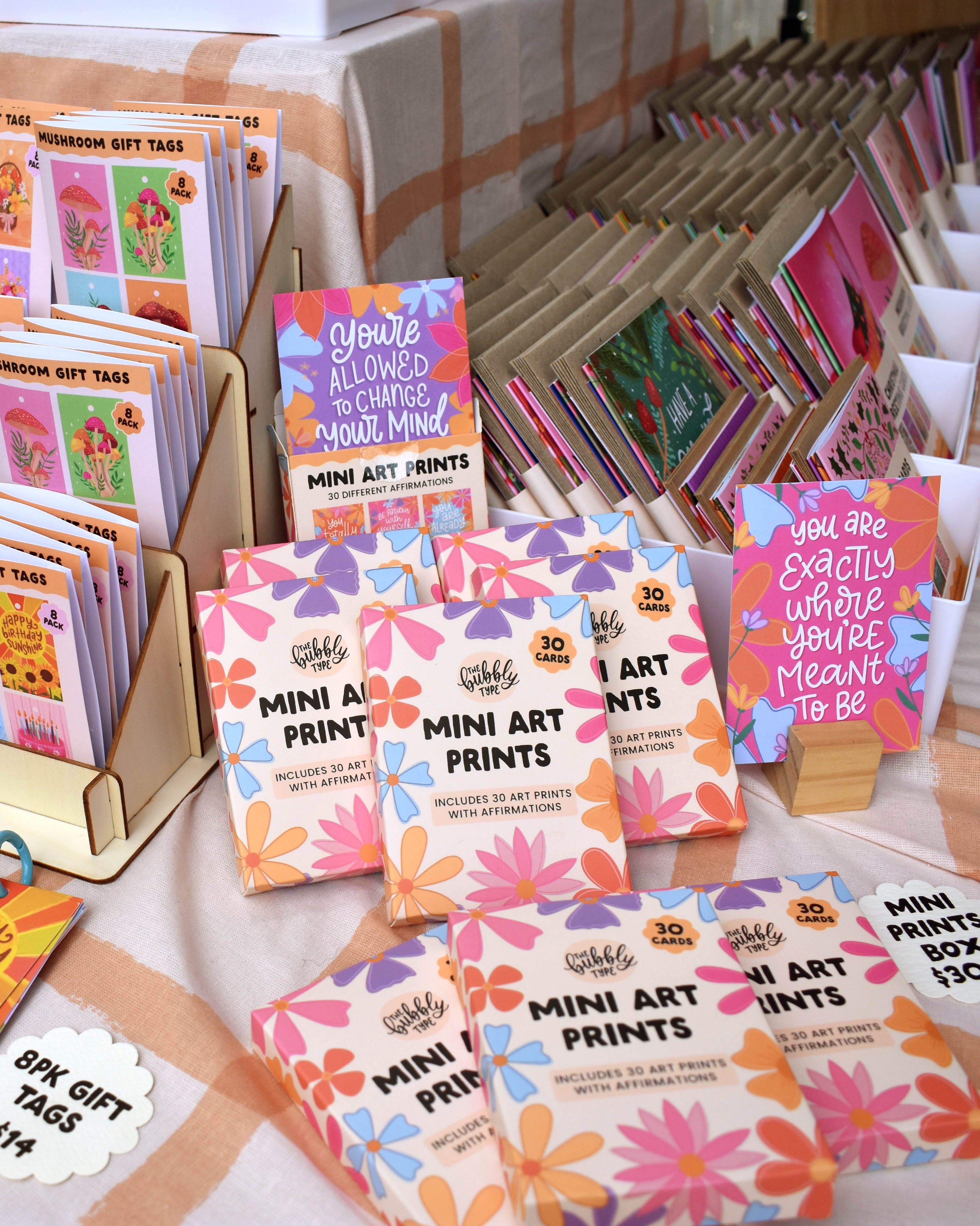 a close up shot of our mini art print affirmation cards display at the market with our greeting card bundles visible to the right.