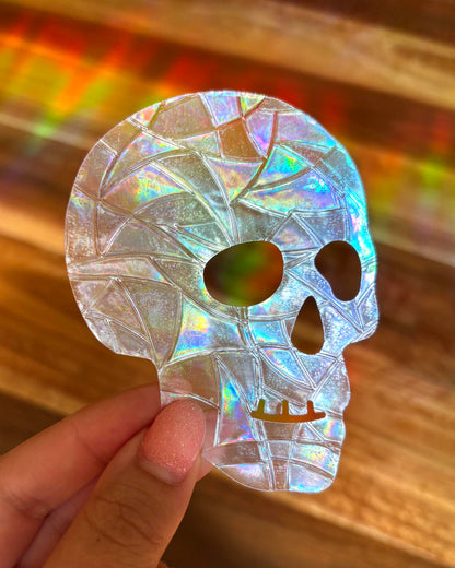 Holographic skull-shaped object held by a hand with a blurred background