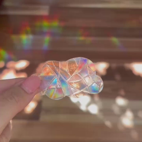 Cloud shaped sun catcher with rainbows shown in the background.